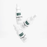 Three bottles of ZMZM Labs Vitamin Glow Serum on a white background