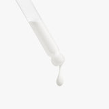 White dropper with a drop of liquid on a light gray background