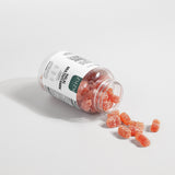 ZMZM Labs Jar of gummy vitamins with scattered gummies on a light background