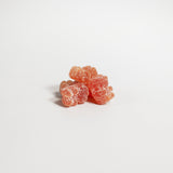 Three pink gummy bears on a white background